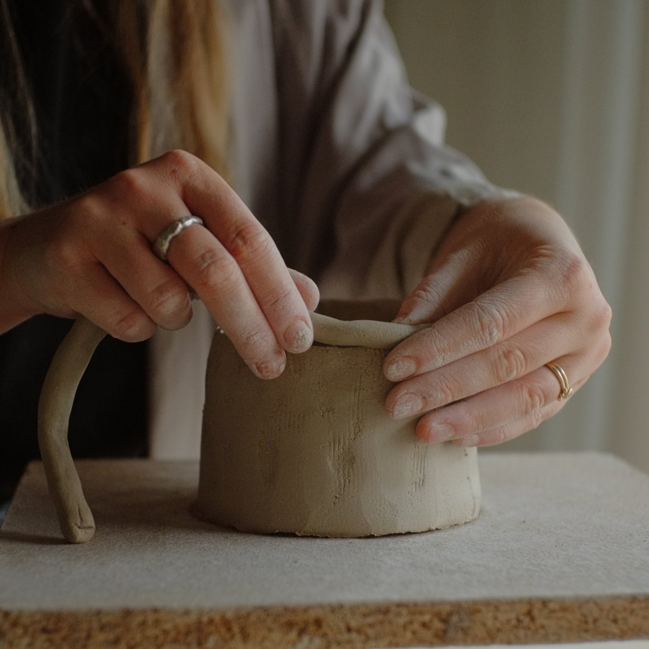 Person coilbuilding object with a focus on hands and craftsmanship